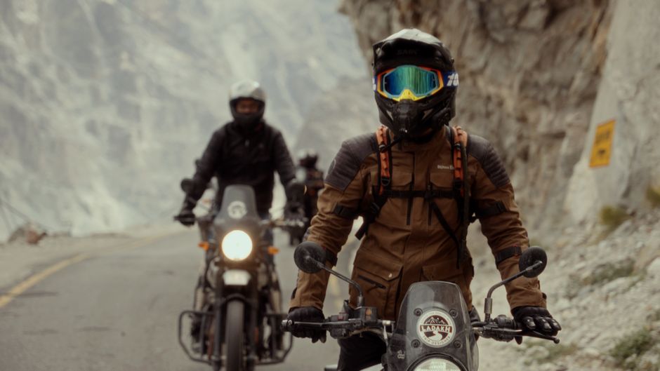 Motorcyclists ride through a mountain pass, showcasing adventure and exploration.